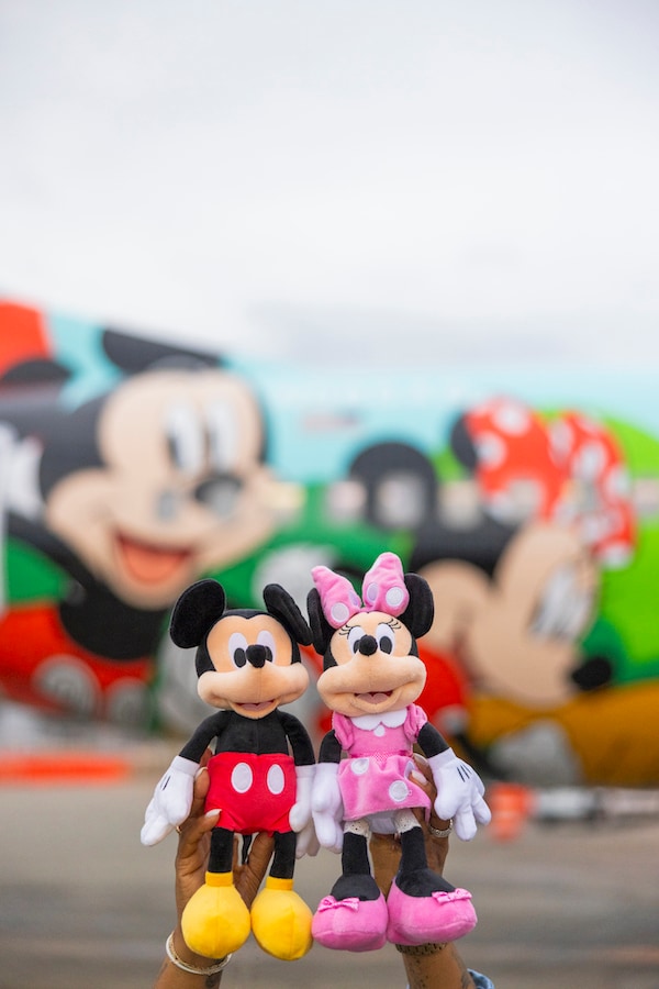 Plush Mickey Mouse and Minnie Mouse with guests - Alaska Airlines Reveals Its New Disneyland Resort-Themed Plane “Mickey’s Toontown Express”