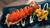 A lobster tail drizzled with sauce
