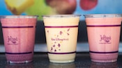 Three refreshing tropical smoothies in plastic cups