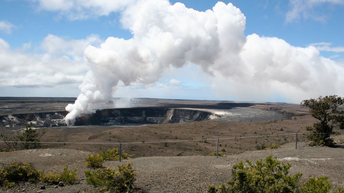 A plume of steam fills the air at a volcanic vent