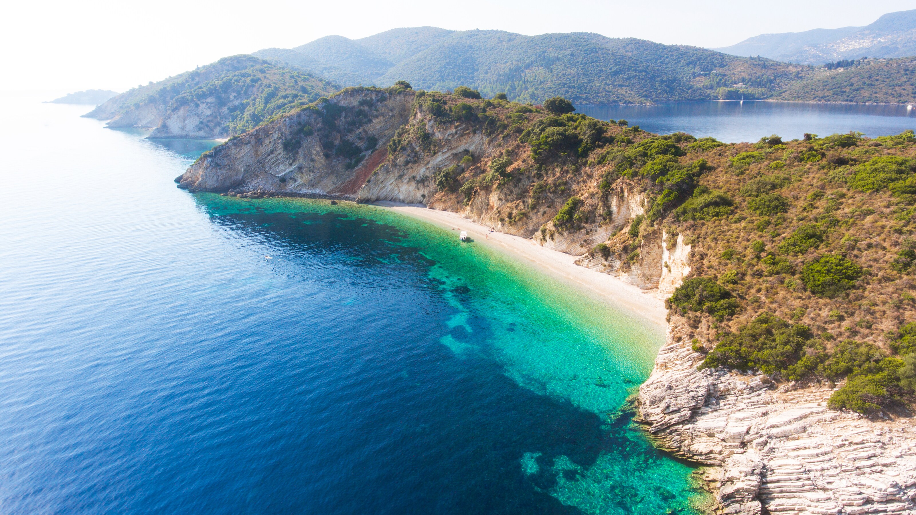 A verdant coastline with steep cliffs and tranquil waters
