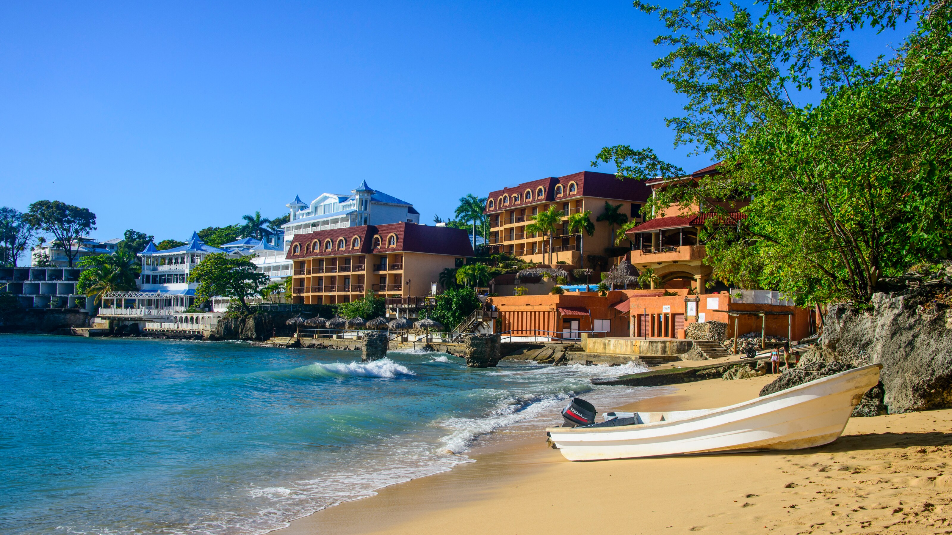 A motorboat on the beach next to waterfront buildings