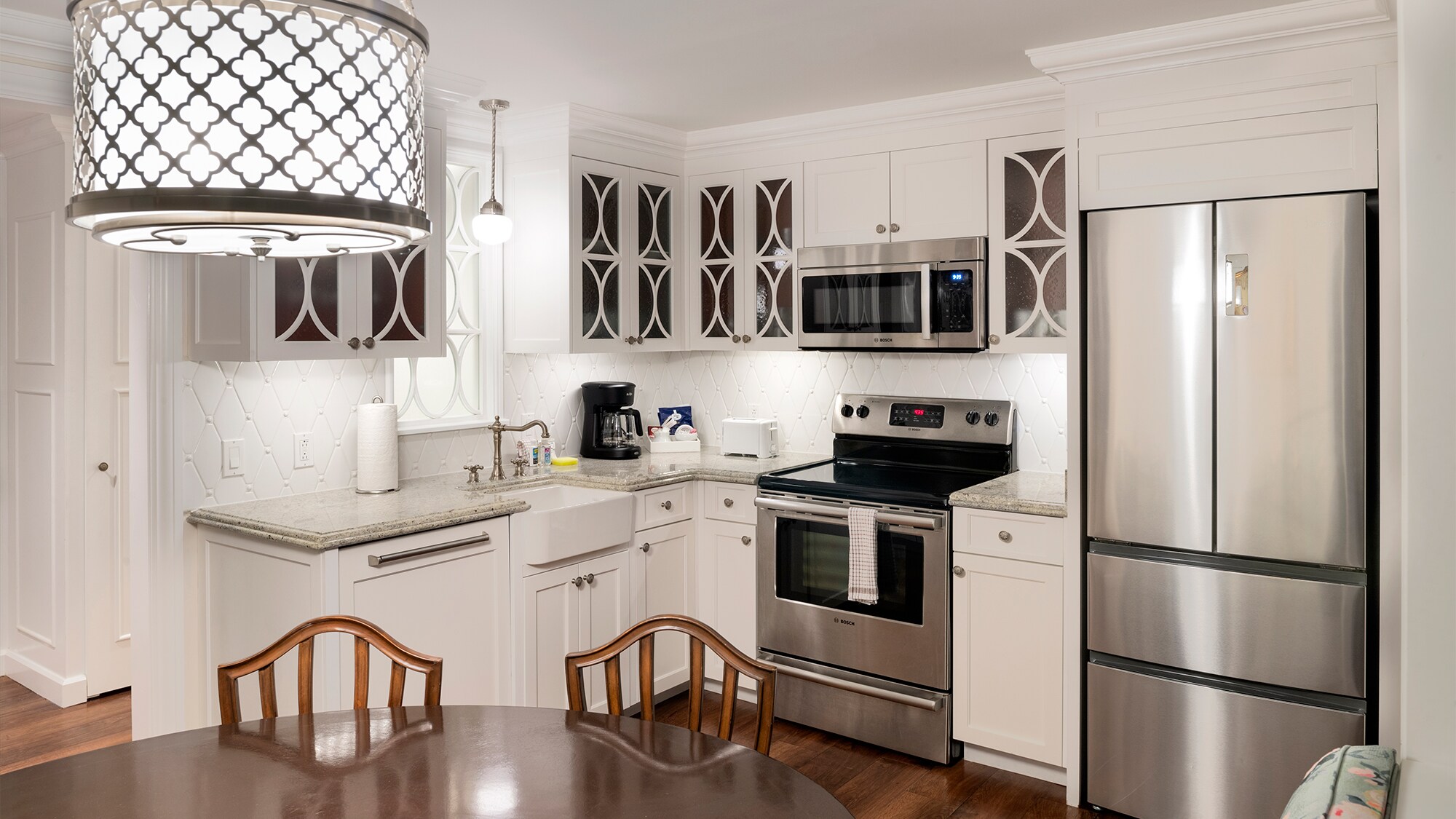 A kitchen area with a refrigerator, oven, microwave and a sink