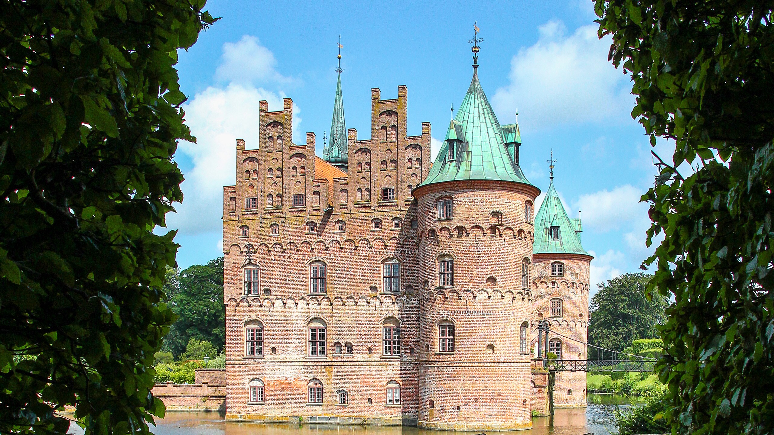 A castle on a lake surrounded by trees