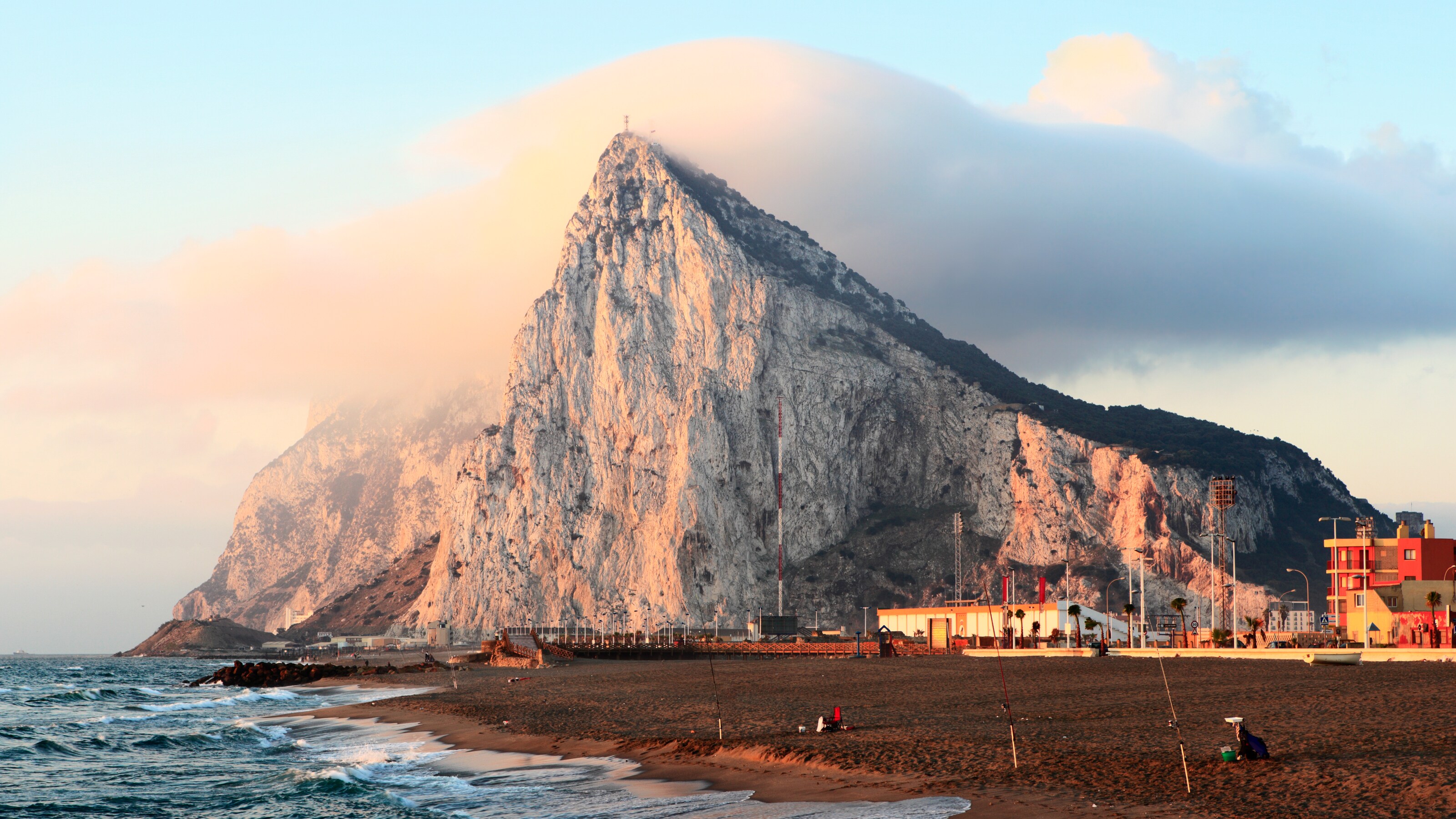 The waterline meets an enormous steep rockface and a dirt beach