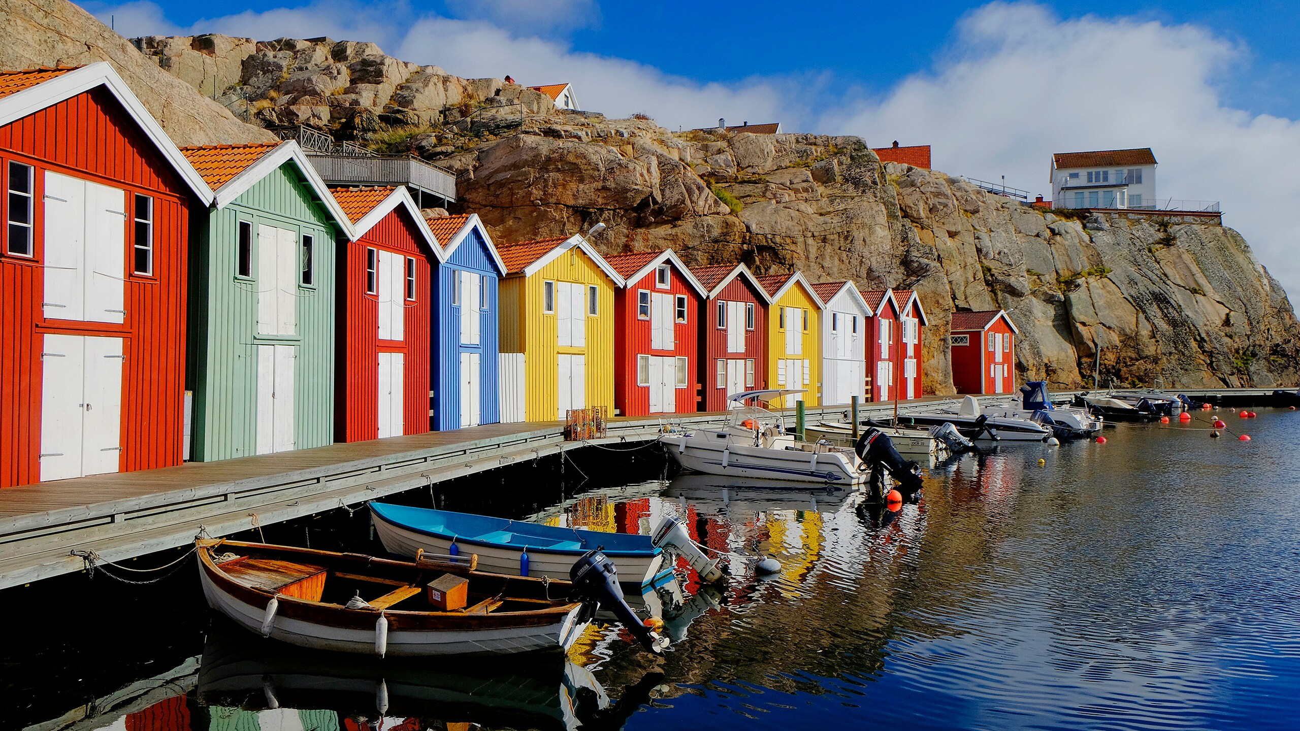 Houses on a cliff near a marina filled with boats