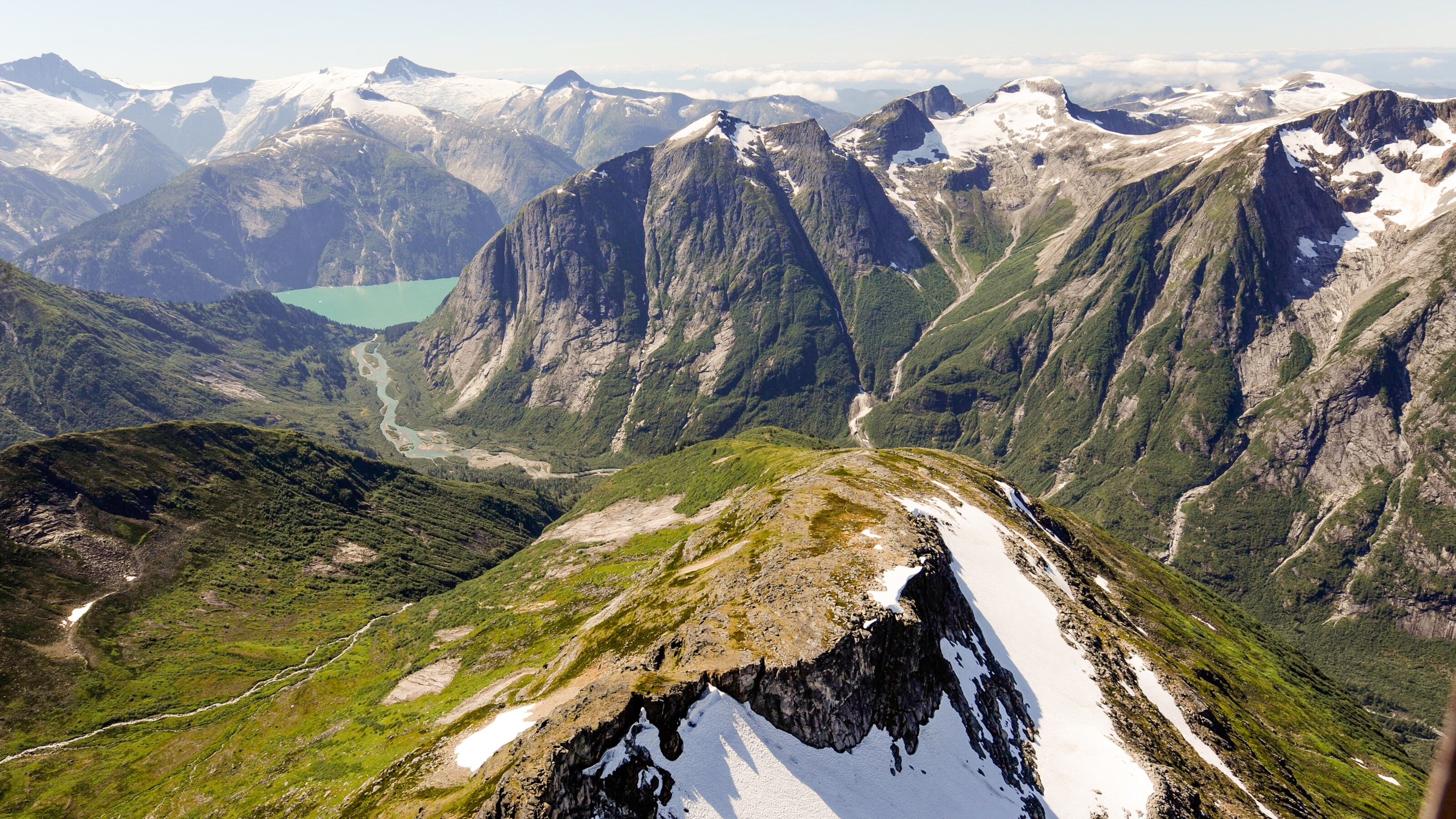 Aerial shot of snow capped mountains with steep cliff faces and the valleys between them