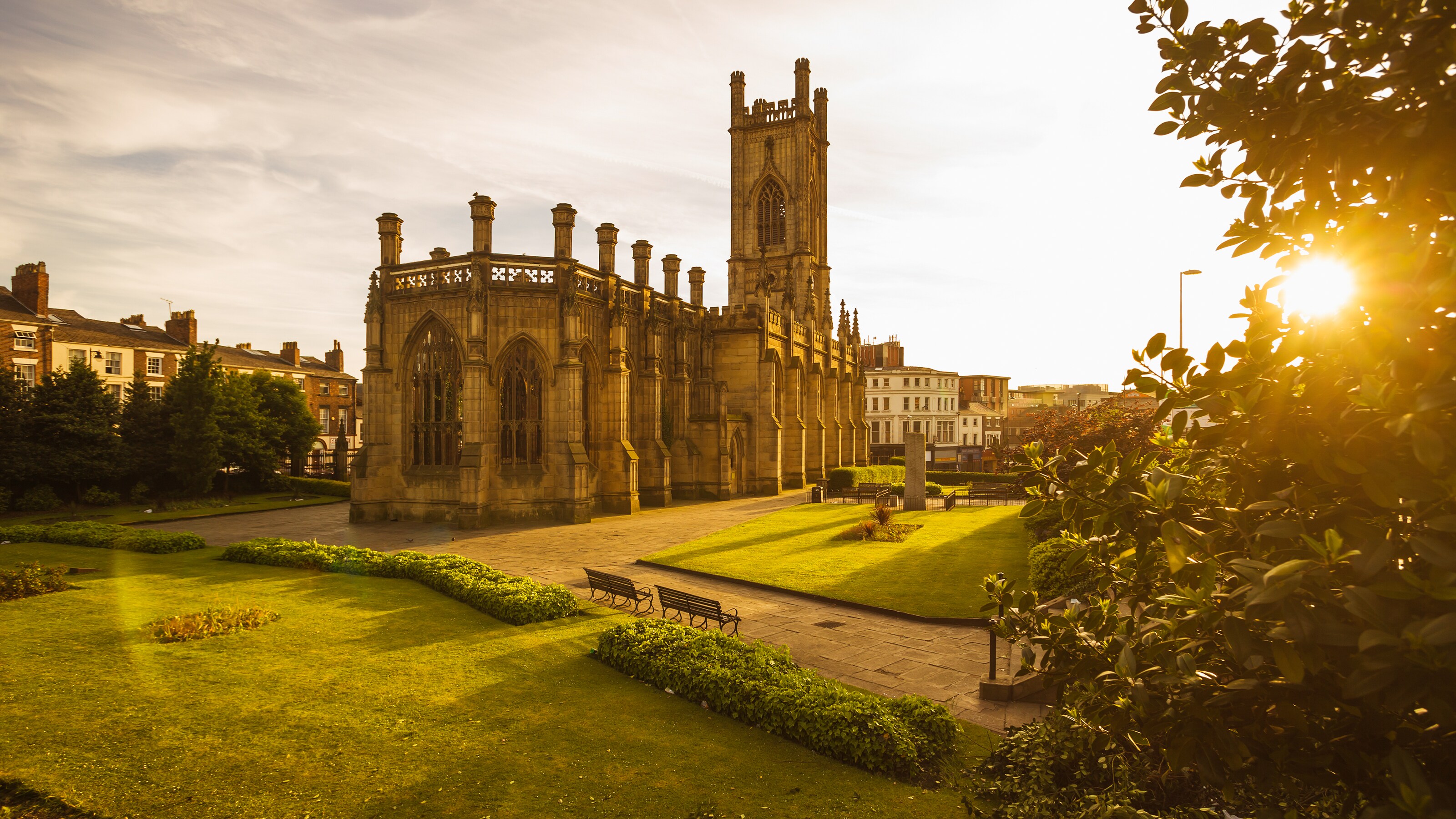 A well manicured grass lawn in front of an old, Baroque style church building
