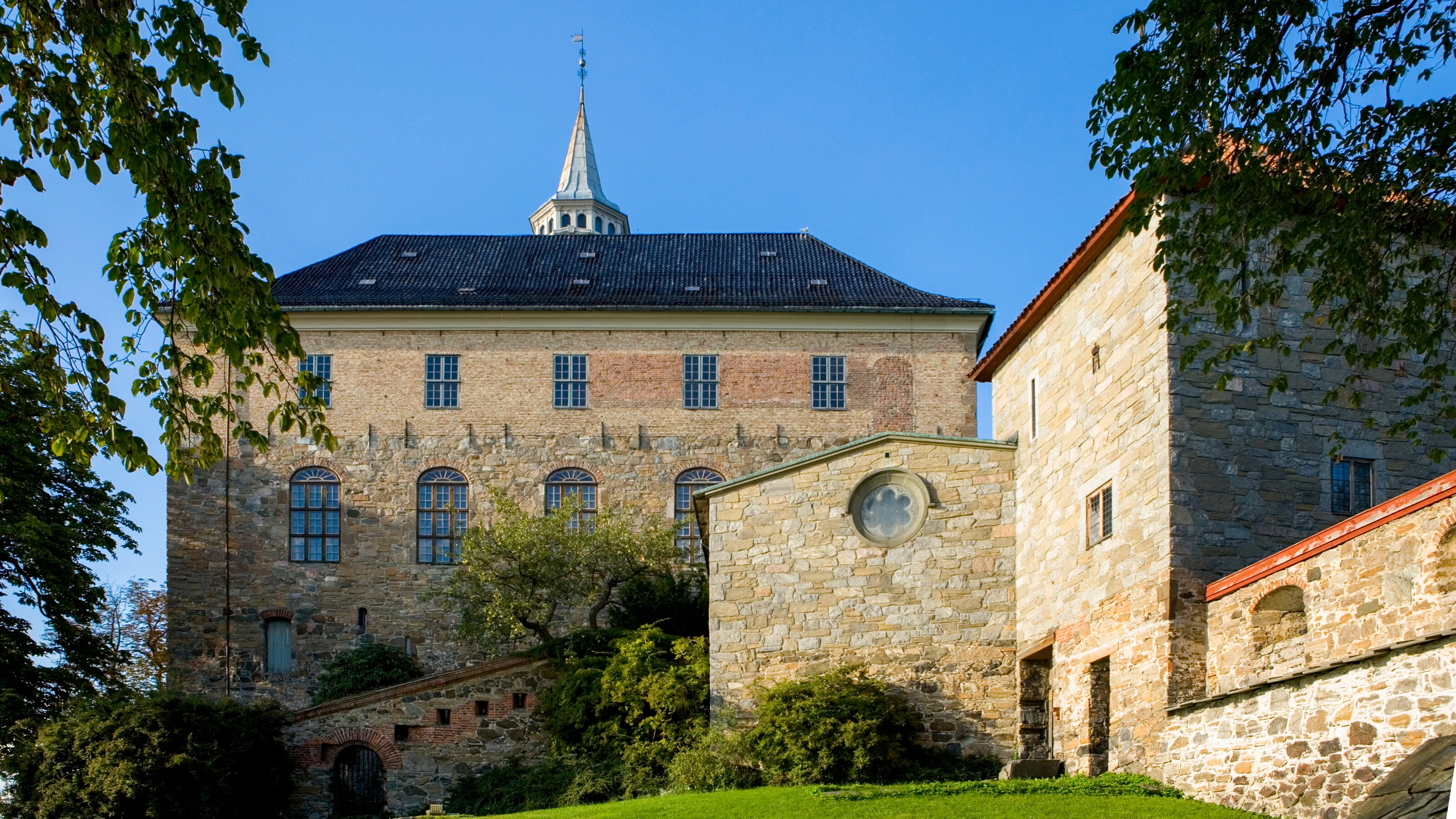 Stone, castle like building with large windows and a tower