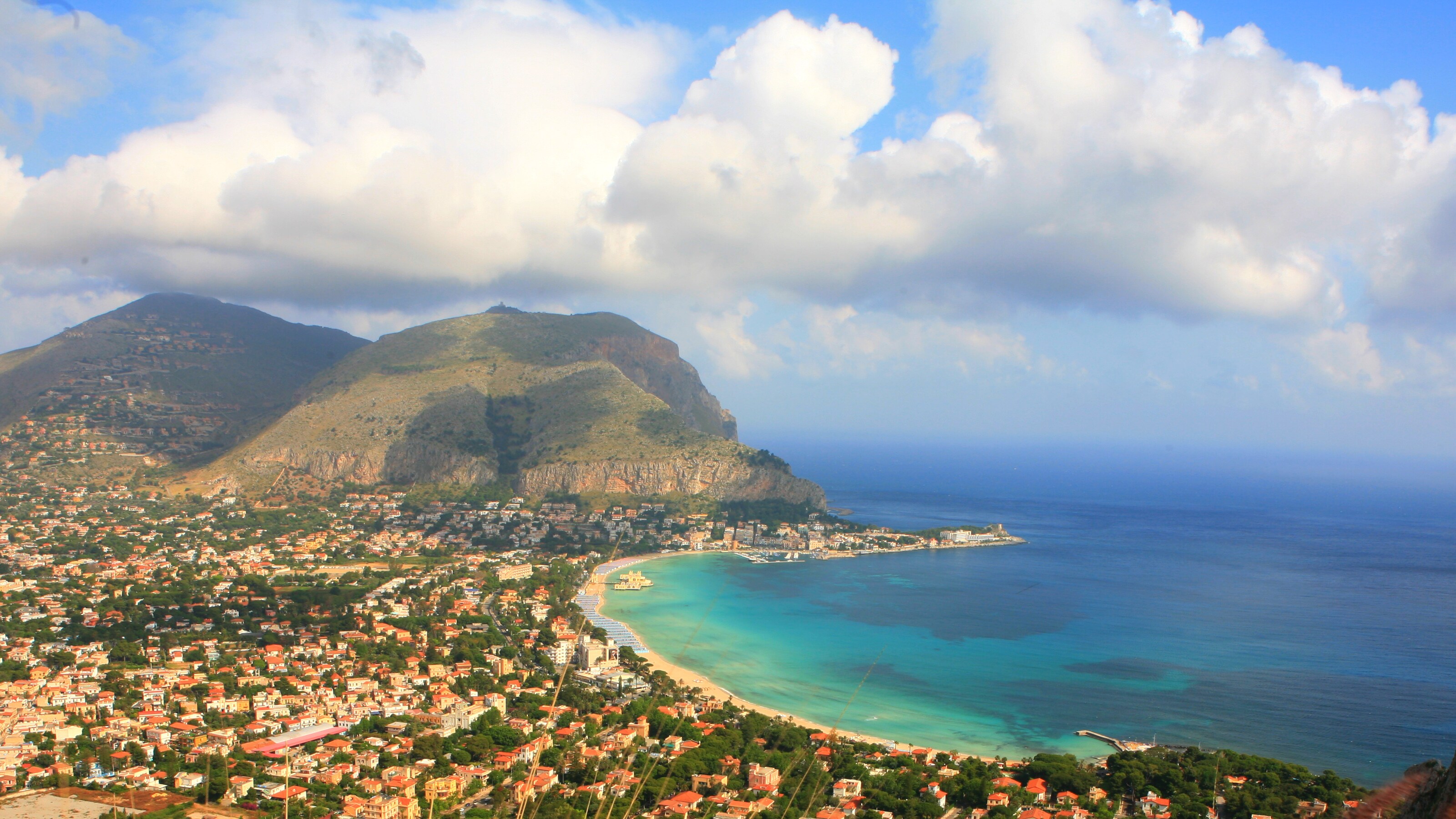 A bay, a mountain, trees and buildings
