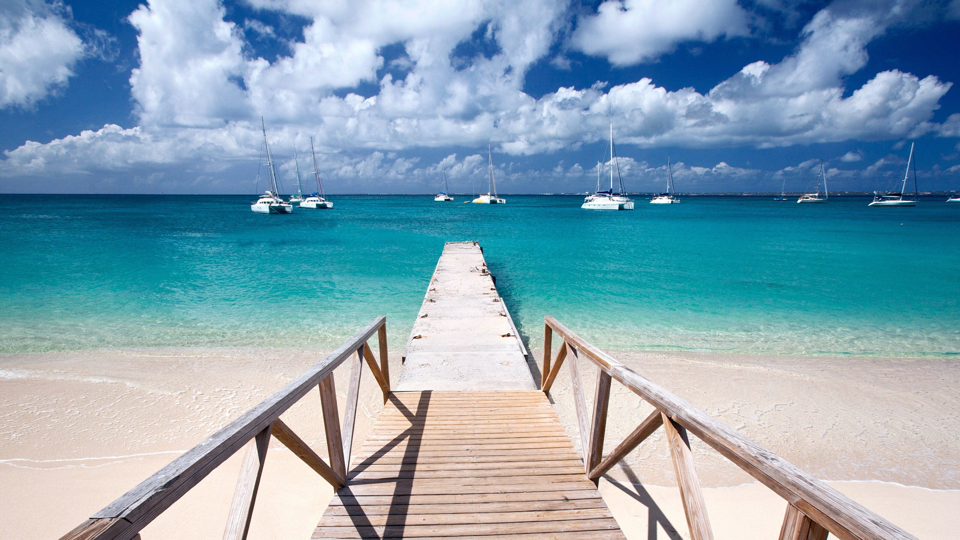 A pier extending into the water, with several boats behind it