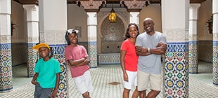 A Mom, Dad, and their two sons pose for a family portrait in the Morocco Pavilion at Epcot.