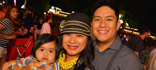 A Mom, Dad, and their infant child, all smiles at the end of the day at Main Street Station.
