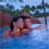 With the beachfront in the background, a couple lounges together in the adults only whirlpool spa at Alohi Point of Aulani Resort and Spa