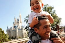  Chilean miner rescuer Roberto Cristian Rios is all smiles as he gives his son, Robert Alex Rios (age 4), a ride atop his shoulders in front of Cinderella Castle at the Walt Disney World Resort