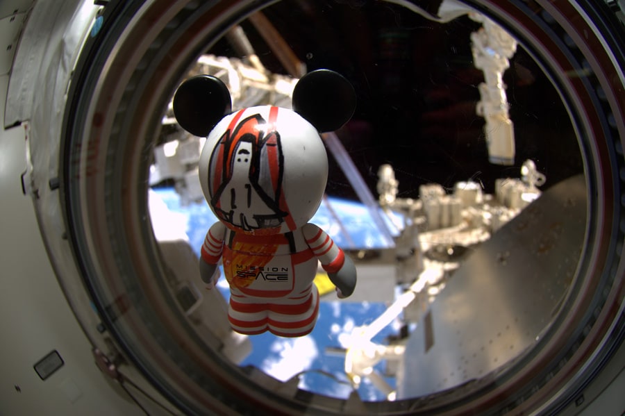 The customized Mission:SPACE-inspired Vinylmation, looks to the Earth as it floats inside Space Shuttle Atlantis
