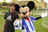 Soccer Player Lionel Messi Kicks Off a Game with Mickey Mouse
