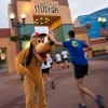 Runners receive a high-five from Pluto during their run at Disney’s Hollywood Studios.