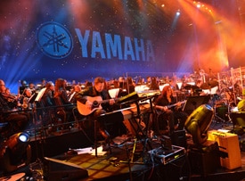A 60-piece orchestra led by Nathan East and James Newton Howard performs during Yamaha’s 125th Anniversary Concert