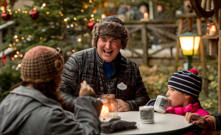 Family enjoying laughs and hot cocoa on their European vacation on the Adventures by Disney Danube River Cruise
