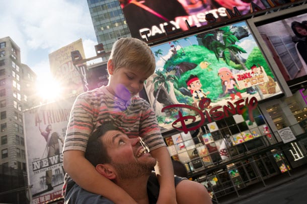 Father with son on shoulders in Times Square on Adventures by Disney New York City vacation