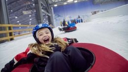 Kids enjoy snow tubing in Cologne, Germany at indoor winter park on Adventures by Disney Rhine River Cruise