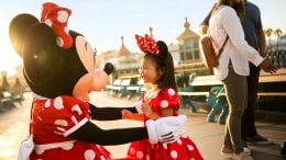 Minnie Mouse hugs young girl dressed as Minnie Mouse at Disney California Adventure park