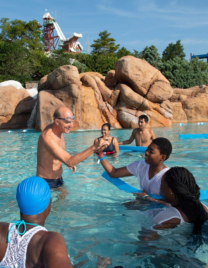 Olympic gold medal swimmer Rowdy Gaines talks with swimmers at the 2019 "World's Largest Swimming Lesson" event at Disney's Blizzard Beach