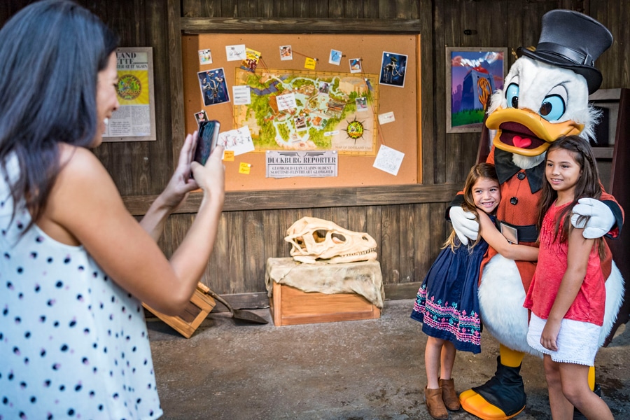 Mom takes picture of kids meeting Scrooge McDuck during Donald’s Dino-Bash! at Disney's Animal Kingdom park