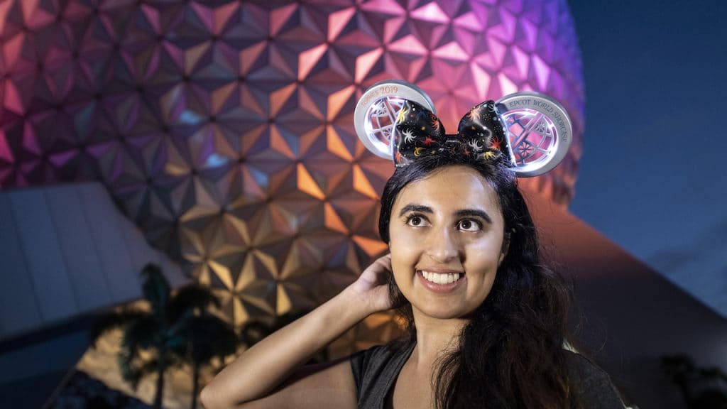 Woman wearing the light-up Minnie Mouse ear headband celebrating ‘IllumiNations Reflections of Earth’