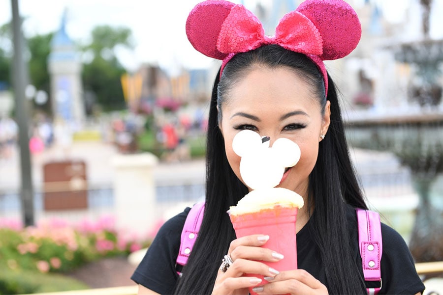 Woman wearing the Imagination Pink Minnie Mouse ear headband at Magic Kingdom Park