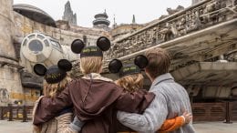 Guests wearing Mickey Ears pose in Star Wars: Galaxy's Edge at Disneyland park