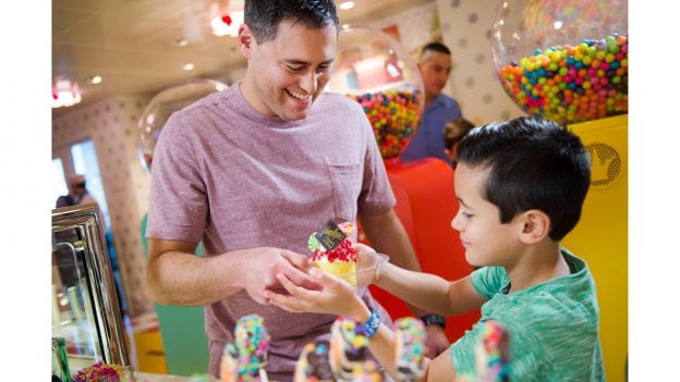Father and son look at treats in Vanellope’s Sweets and Treats aboard the Disney Dream