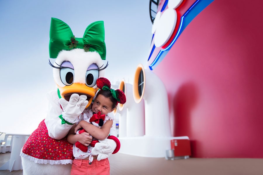 Daisy Duck hugs a young guest aboard Disney Cruise Line