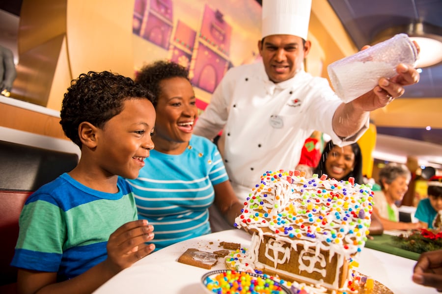 Family decorating a gingerbread house on Disney Cruise Line