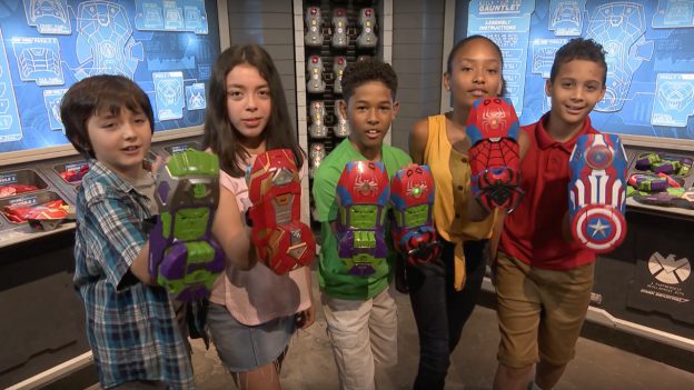 A group of kids show their custom built Super Hero Gauntlets at Super Hero Headquarters in Disney Springs