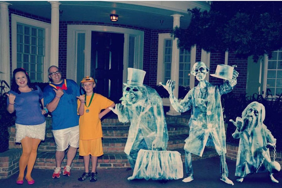 Family wearing Daisy, Donald and Pluto costumes take a Disney PhotoPass MagicShot with the Hitchhiking Ghosts