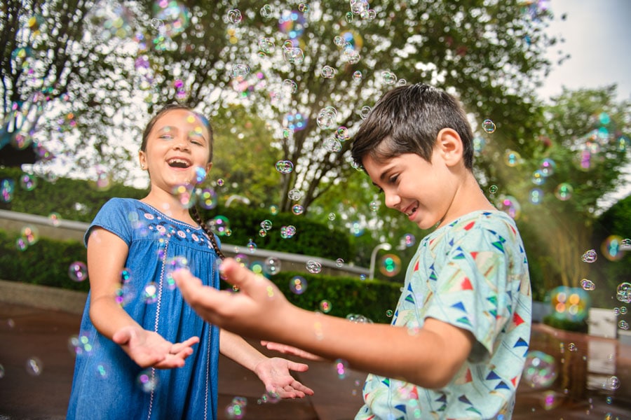 Kids play with bubbles in a Disney PhotoPass photo at Magic Kingdom Park