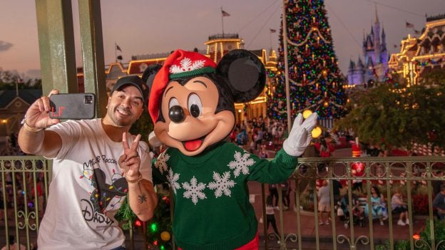 Luis Fonsi poses with Mickey Mouse during Mickey's Very Merry Christmas Party at Magic Kingdom Park
