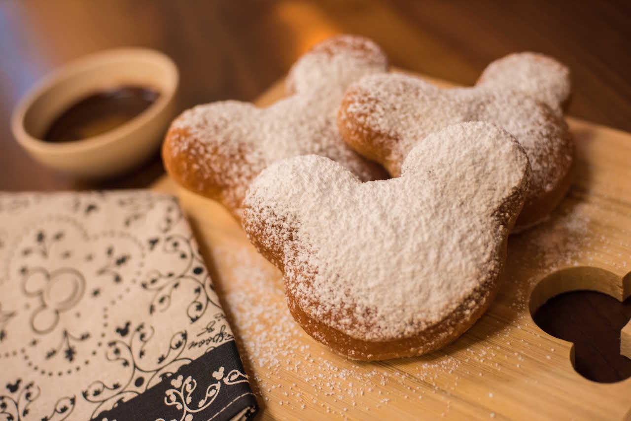 Mickey Mouse shaped Beignets with powdered sugar on top