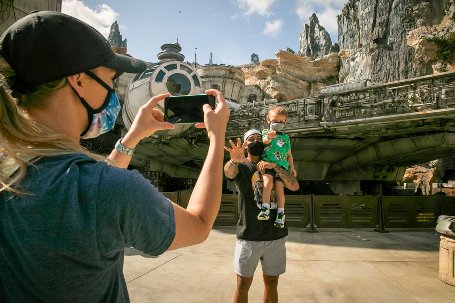 Guests take a photo in front of the Millennium Falcon in Star Wars: Galaxy's Edge at Disney's Hollywood Studios
