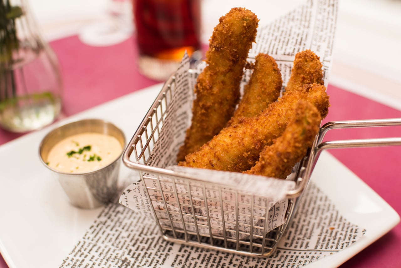 Fried pickles with dipping sauce on a plate