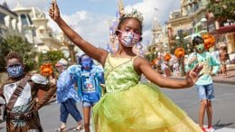 Kids wearing Halloween costumes and matching face coverings at Magic Kingdom Park