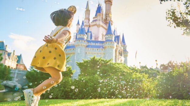 Girl running in front of Cinderella Castle