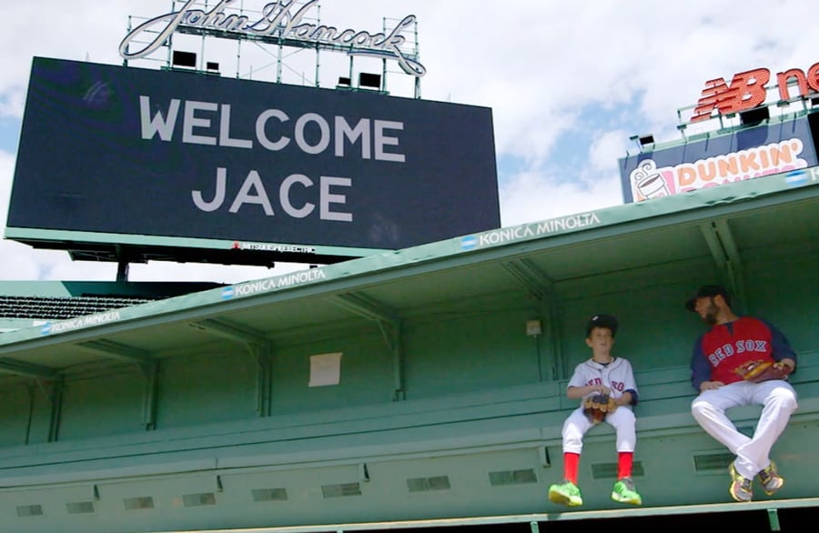 Make-A-Wish Kid Jace Andrews and Dustin Pedroia sit below "Welcome Jace" Sign at Fenway Park