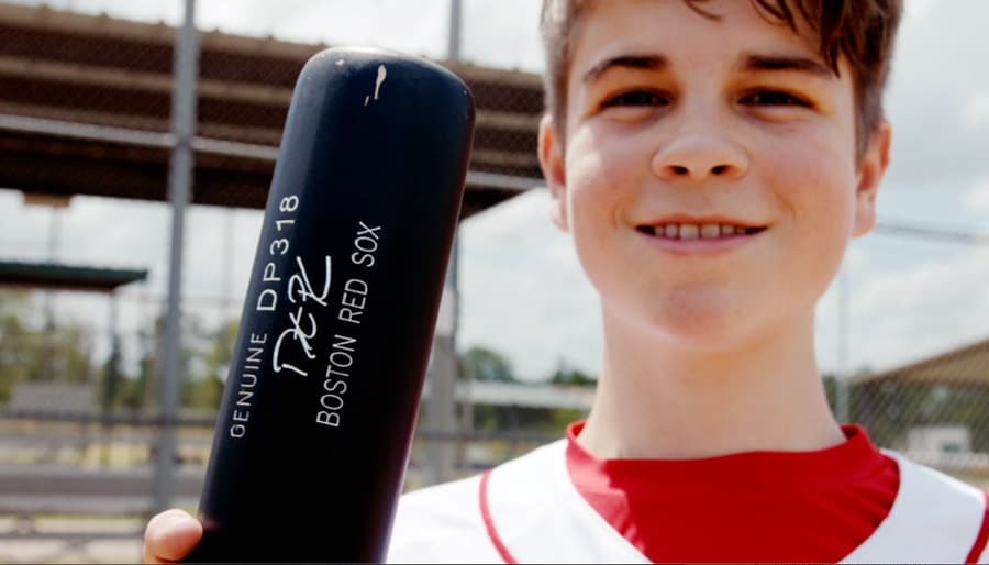 Make-A-Wish Kid Jace Andrews holds a Boston Red Sox baseball bat