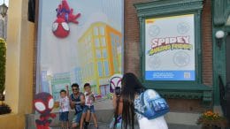 Guests take a photo at the "Spidey and his Amazing Friends" photo wall in Hollywood Land in Disney California Adventure park