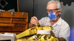 Cast member adds gold detail to decor at Magic Kingdom Park