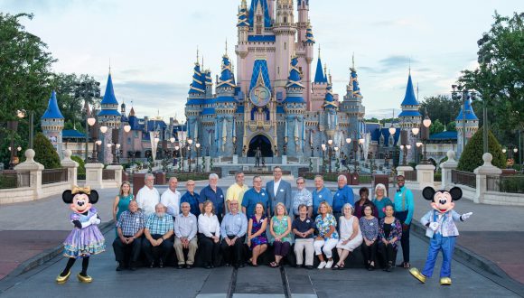 Members of the Walt Disney World 'Class of 1971' with Mickey and Minnie Mouse at Magic Kingdom Park.