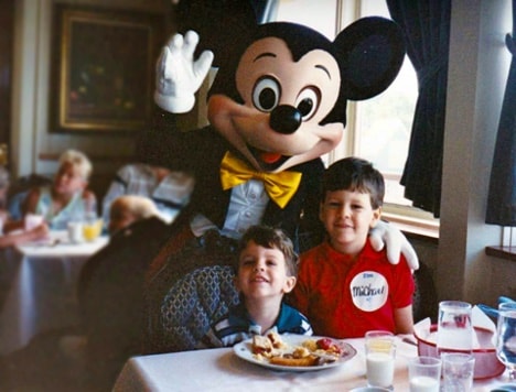 Young Steven and his brother, Michael, confer with Steven’s future boss aboard the Empress Lilly Character Breakfast in Walt Disney World Village, c. 1990.